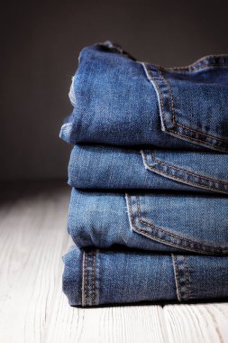 Kot pantolon giyiyordu. Makine dikişi yakın. Mavili Denim dokusu. Eski giysileri tamir etme kavramı. Dikiş fabrikası. Modaya uygun yaşlanma kıyafetleri. Kot yığını. 