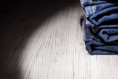 Kot pantolon giyiyordu. Makine dikişi yakın. Mavili Denim dokusu. Eski giysileri tamir etme kavramı. Dikiş fabrikası. Modaya uygun yaşlanma kıyafetleri. Kot yığını. 