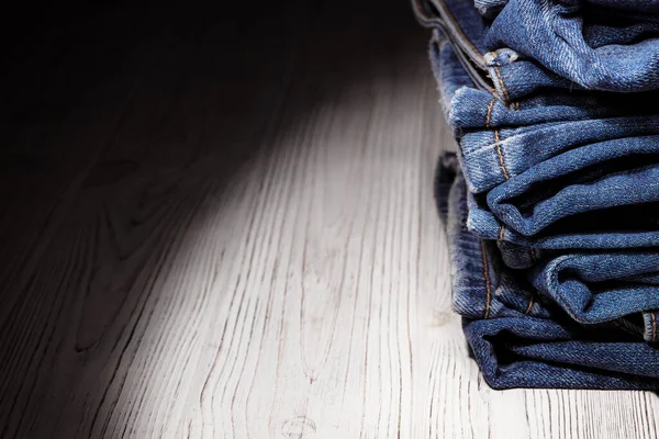 Kot pantolon giyiyordu. Makine dikişi yakın. Mavili Denim dokusu. Eski giysileri tamir etme kavramı. Dikiş fabrikası. Modaya uygun yaşlanma kıyafetleri. Kot yığını. 