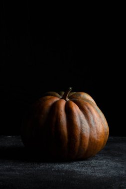 Koyu arkaplanda taze balkabağı. Dokulu turuncu balkabağı. Sonbahar hasadı. Balkabağı turtası için içerik.