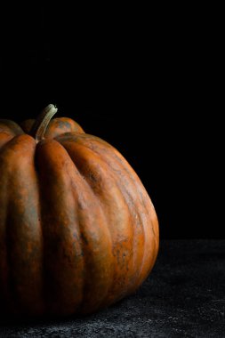 Koyu arkaplanda taze balkabağı. Dokulu turuncu balkabağı. Sonbahar hasadı. Balkabağı turtası için içerik.