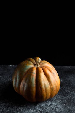 Koyu arkaplanda taze balkabağı. Dokulu turuncu balkabağı. Sonbahar hasadı. Balkabağı turtası için içerik.