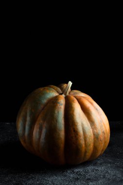 Koyu arkaplanda taze balkabağı. Dokulu turuncu balkabağı. Sonbahar hasadı. Balkabağı turtası için içerik.