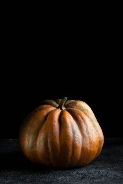 Koyu arkaplanda taze balkabağı. Dokulu turuncu balkabağı. Sonbahar hasadı. Balkabağı turtası için içerik.