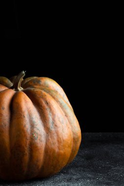 Koyu arkaplanda taze balkabağı. Dokulu turuncu balkabağı. Sonbahar hasadı. Balkabağı turtası için içerik.