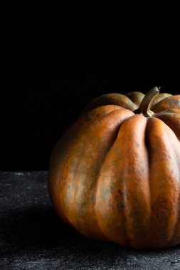Koyu arkaplanda taze balkabağı. Dokulu turuncu balkabağı. Sonbahar hasadı. Balkabağı turtası için içerik.