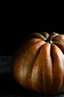 Koyu arkaplanda taze balkabağı. Dokulu turuncu balkabağı. Sonbahar hasadı. Balkabağı turtası için içerik.