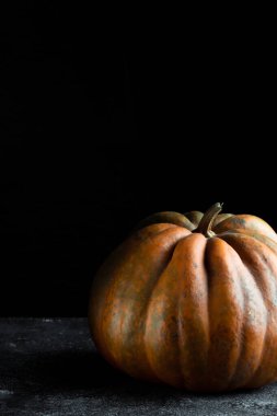 Koyu arkaplanda taze balkabağı. Dokulu turuncu balkabağı. Sonbahar hasadı. Balkabağı turtası için içerik.
