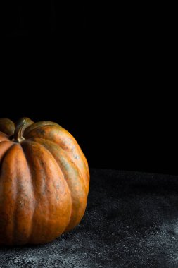 Koyu arkaplanda taze balkabağı. Dokulu turuncu balkabağı. Sonbahar hasadı. Balkabağı turtası için içerik.