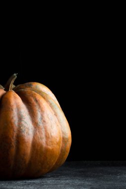 Koyu arkaplanda taze balkabağı. Dokulu turuncu balkabağı. Sonbahar hasadı. Balkabağı turtası için içerik.