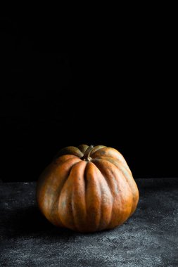 Koyu arkaplanda taze balkabağı. Dokulu turuncu balkabağı. Sonbahar hasadı. Balkabağı turtası için içerik.