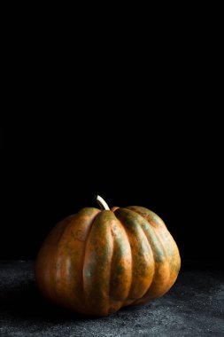 Koyu arkaplanda taze balkabağı. Dokulu turuncu balkabağı. Sonbahar hasadı. Balkabağı turtası için içerik.