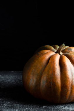 Koyu arkaplanda taze balkabağı. Dokulu turuncu balkabağı. Sonbahar hasadı. Balkabağı turtası için içerik.