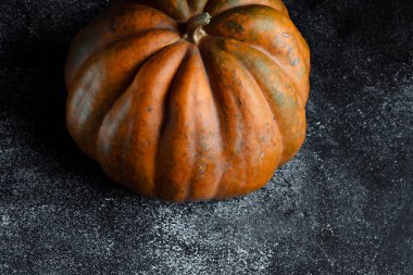 Koyu arkaplanda taze balkabağı. Dokulu turuncu balkabağı. Sonbahar hasadı. Balkabağı turtası için içerik.