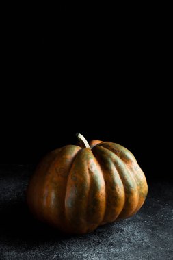 Koyu arkaplanda taze balkabağı. Dokulu turuncu balkabağı. Sonbahar hasadı. Balkabağı turtası için içerik.