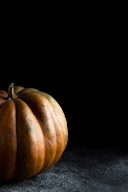 Koyu arkaplanda taze balkabağı. Dokulu turuncu balkabağı. Sonbahar hasadı. Balkabağı turtası için içerik.
