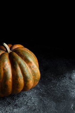 Koyu arkaplanda taze balkabağı. Dokulu turuncu balkabağı. Sonbahar hasadı. Balkabağı turtası için içerik.