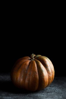 Koyu arkaplanda taze balkabağı. Dokulu turuncu balkabağı. Sonbahar hasadı. Balkabağı turtası için içerik.