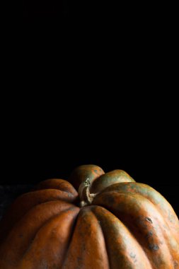Koyu arkaplanda taze balkabağı. Dokulu turuncu balkabağı. Sonbahar hasadı. Balkabağı turtası için içerik.