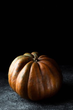 Koyu arkaplanda taze balkabağı. Dokulu turuncu balkabağı. Sonbahar hasadı. Balkabağı turtası için içerik.