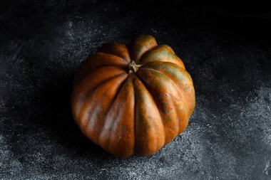 Koyu arkaplanda taze balkabağı. Dokulu turuncu balkabağı. Sonbahar hasadı. Balkabağı turtası için içerik.