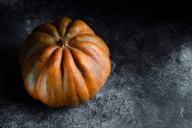 Koyu arkaplanda taze balkabağı. Dokulu turuncu balkabağı. Sonbahar hasadı. Balkabağı turtası için içerik.