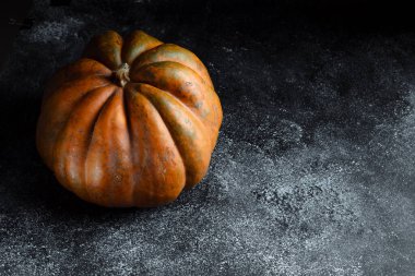 Koyu arkaplanda taze balkabağı. Dokulu turuncu balkabağı. Sonbahar hasadı. Balkabağı turtası için içerik.