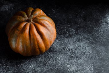 Koyu arkaplanda taze balkabağı. Dokulu turuncu balkabağı. Sonbahar hasadı. Balkabağı turtası için içerik.