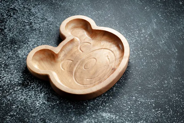 A plate for children in the shape of a bear is made of wood for serving snacks, fruits, nuts, cheeses, meat and original serving of main dishes. Accessories for a modern kitchen.