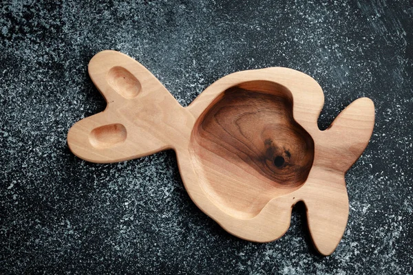 A plate for children in the shape of a bunny is made of wood for serving snacks, fruits, nuts, cheeses, meat and original serving of main dishes. Accessories for a modern kitchen.