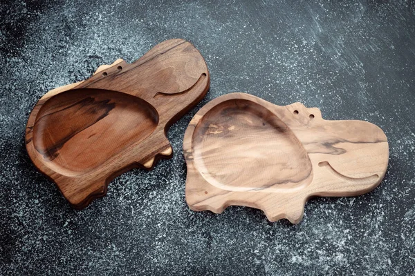 The children\'s plate in the shape of a hippopotamus is made of wood for serving snacks, fruits, nuts, cheeses, meat and original serving of main dishes. Accessories for a modern kitchen.