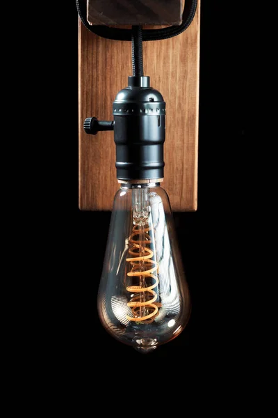 Vintage wall lamp to illuminate the terrace. Antique lamp with Edison bulb. The concept of saving energy or lack of ideas. Turned off lamp on a dark background.