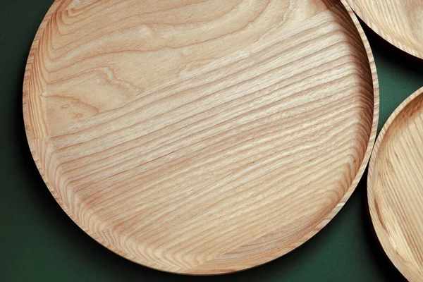 Yeşil arka planda tahta düz plakalar. Ekolojik sofra takımı kavramı. Modern mutfak ürünleri. Sıfır emisyon.