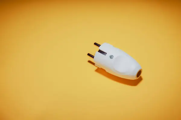 Electrical plug with European standard socket. The concept of electrical equipment. Concept of a day without electricity. Eco-friendly fuels. Yellow background.