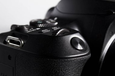 Beyaz arka planda siyah kamera. Kamera düğmelerini ve kontrollerini kapatın. Kamera gövdesinin makro fotoğrafı. Dijital SLR kamera flaşı.