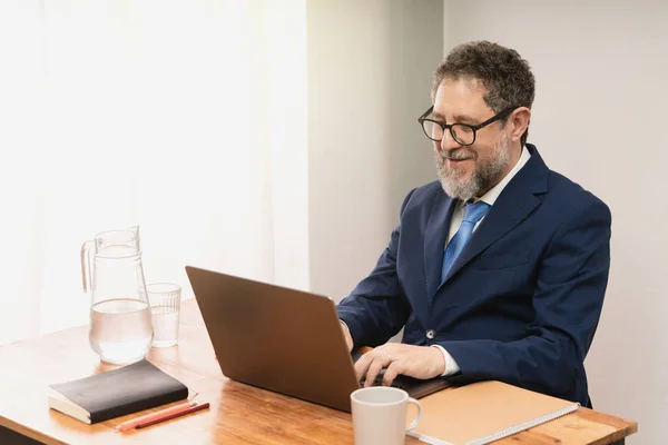 Biznesmen Średnim Wieku Garniturze Krawacie Siedzący Przy Biurku Biurze Piszący — Zdjęcie stockowe