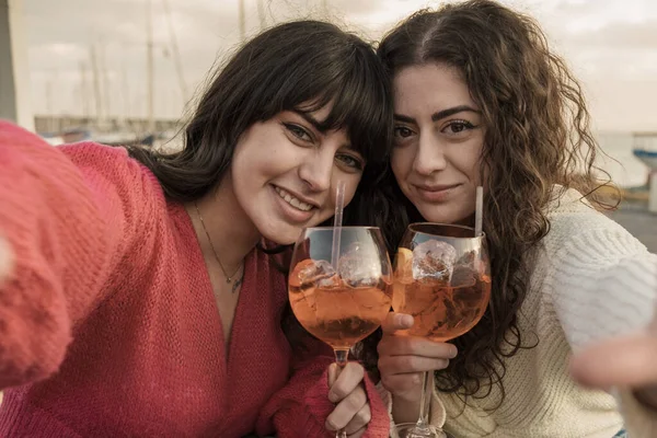 Selfie Two Joyful Women Toasting Aperol Spritz Cocktails Waterfront Sun — Stock Photo, Image