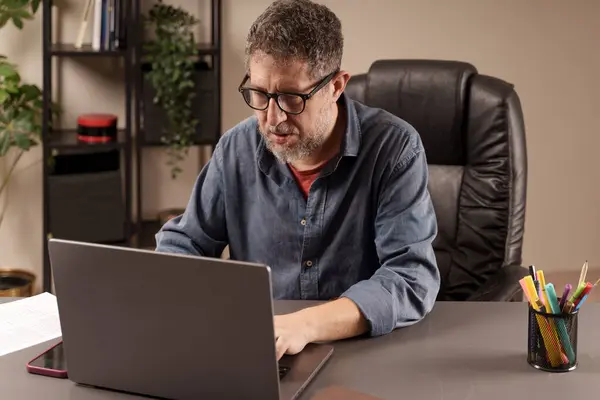 Konzentrierter Mann Der Einem Homeoffice Umfeld Gewissenhaft Seinem Laptop Arbeitet — Stockfoto