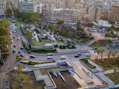 Hava perspektifi, gün sona ererken Catania 'nın dinamik trafiğini ve şehir planlarını yakalar. Şehrin araç hareketlerinin karışımını sergiliyor ve solan gökyüzüne karşı mimari yapılar kuruyor..