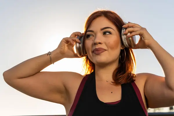 Eine Junge Frau Hält Ihre Kopfhörer Erwartung Einer Entspannten Musikstunde lizenzfreie Stockbilder