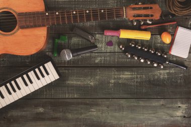 Müzik ve müzik arkaplanı reklam ve afişler için fotokopi alanı - ahşap bir yüzeye yerleştirilmiş çeşitli müzik enstrümanları ve kayıt ekipmanları - müzik yaratmak için temel araçlar