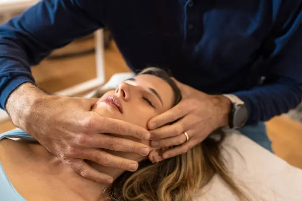 stock image Osteopath performing delicate cranial adjustment - Technique to alleviate tension and enhance relaxation.