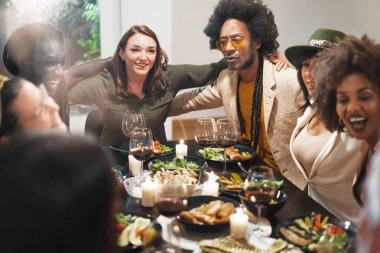 Çeşitli arkadaşlar gülüyor ve yemek yiyorlar - evde keyifli bir akşam yemeği atmosferi - dostluk ve kutlama anları