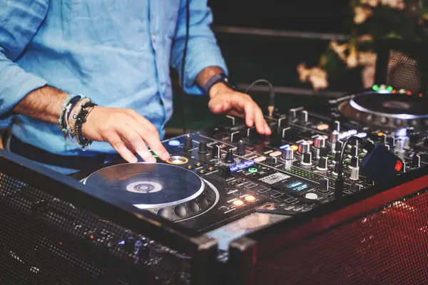 Profesyonel DJ ekipmanlarıyla müziği karıştıran canlı ve enerjik bir gece hayatı sahnesi sergileyen bir DJ. Müzik, etkinlik ve eğlence içeriği için ideal.
