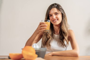 Portakal suyu içen kadın - sağlıklı yaşam tarzı - taze içecek, gülümseyen kadın - beslenme ve sağlık, C vitamini ferahlatıcı içecek.