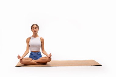 Young woman in lotus pose on cork yoga mat, with ample space for text or graphics. Perfect for wellness, meditation, and yoga concepts with customizable design elements. clipart