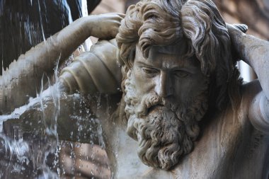 Sicilya, Catania 'daki Amenano Çeşmesi' nin detaylı manzarası. Heykel, nehir tanrısı Amenano 'yu tasvir ediyor. Heykeltraş edilmiş yüzün etrafında dramatik bir şekilde akan su barok sanatını gözler önüne seriyor..