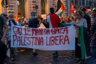 Catania, İtalya - 19 Mayıs 2024: Protestocular akşam gösterileri sırasında Filistin ve Gazze 'yi destekleyen pankart taşıyorlar. Kalabalık kentte toplandı, Filistin bayrakları ve tabelaları devam eden Orta Doğu çatışması ortasında.