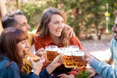 Bahçedeki sıradan bira buluşmaları sırasında doğal grup etkileşimi. Gerçek dostluk anı, doğal kahkahaları ve dışarıdaki gerçek bağlantıları yakalar..