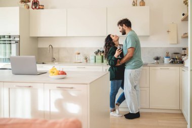 Çağdaş mutfakta romantik anın tadını çıkaran genç çiftler arasındaki otantik etkileşim. Modern yaşam, iş hayatı dengesi ve ilişkiyi birleştiren doğal yaşam tarzı portresi.